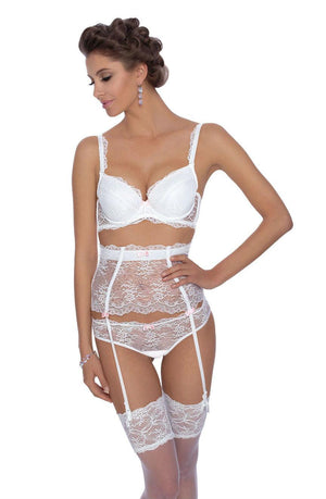 A woman models luxury lingerie, featuring a white lace bra, high-waisted garter belt with garters, and thigh-high sheer stockings. She sports a sophisticated hairdo and wears drop earrings. Posing elegantly with one hand on her hip and the other brushing her hair, she highlights the full rear coverage of the Roza Ambre Brief White from Roza.