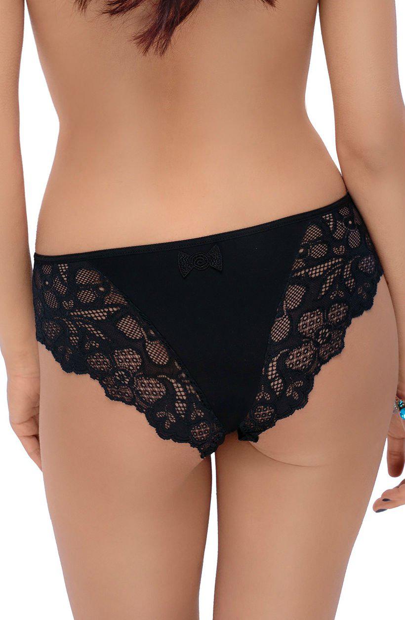 A woman is viewed from behind, adorned in the Roza Czacza Brief Black by the brand Roza. The briefs boast a small decorative bow at the top center and intricate, delicate lace trim on the sides. Her hair flows elegantly down her back, and she accessorizes with a blue bracelet on her left wrist.