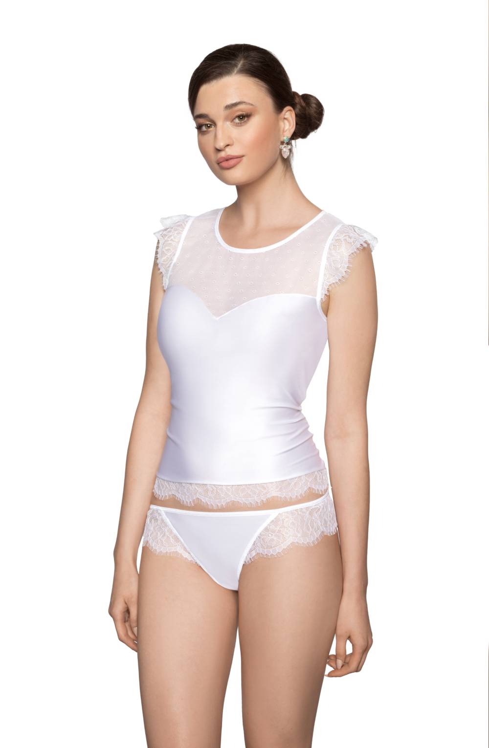 A woman models the Roza Erii White Shirt by Roza, featuring a sleeveless top with sheer eyelash lace details on the shoulders and neckline, paired with matching panties adorned with lace edging. Her hair is styled in a neat bun, complemented by pearl drop earrings. The stretch fabric of the set accentuates her fit against the plain white background.