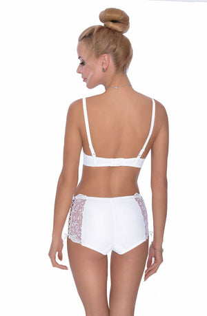 A woman with blonde hair arranged in a bun is seen from the back, wearing the Roza Ginewra Bra White by Roza. The set features a white push-up bra and high-waisted panties adorned with intricate lace embroidery on the sides, exuding an air of elegant bridal wear. The background is plain white.