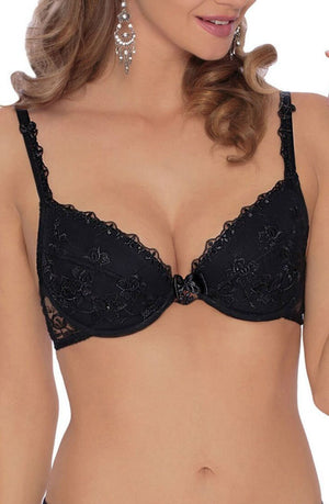 A woman is shown from the neck to the waist wearing the Roza Kalisi Push Up Bra in black, featuring elegant floral embroidery. She has wavy, light brown hair and is accessorized with dangling earrings against a plain white background.