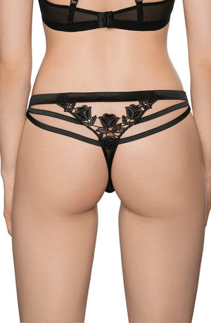 A person is shown from the back wearing the Roza Lisbet Black Thong, featuring black lace lingerie bottoms with floral applique designs and multiple thin straps. The image focuses on the lower back and hips, showcasing the intricate details and fit of this elegant piece by Roza.