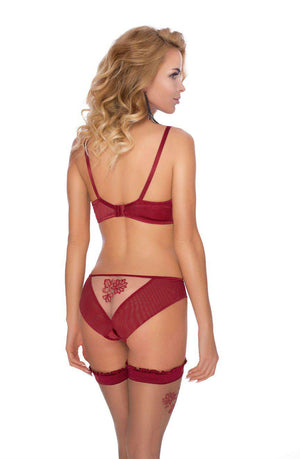 A woman with long blond hair is shown from the back, wearing the Roza Mehendi Brief Claret lingerie set, which includes a matching bra, panties, and garter stockings. The set by Roza features intricate floral lace detailing reminiscent of delicate floral embroidery. She stands against a plain white background, looking to her right.