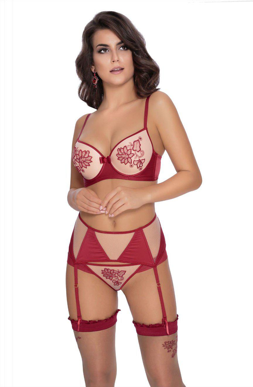 A woman is wearing the Roza Mehendi Push Up Bra Claret with floral embroidery, paired with a garter belt and thigh-high stockings. She stands against a plain white background, looking slightly upward and to the left with her hands lightly resting on her waist.