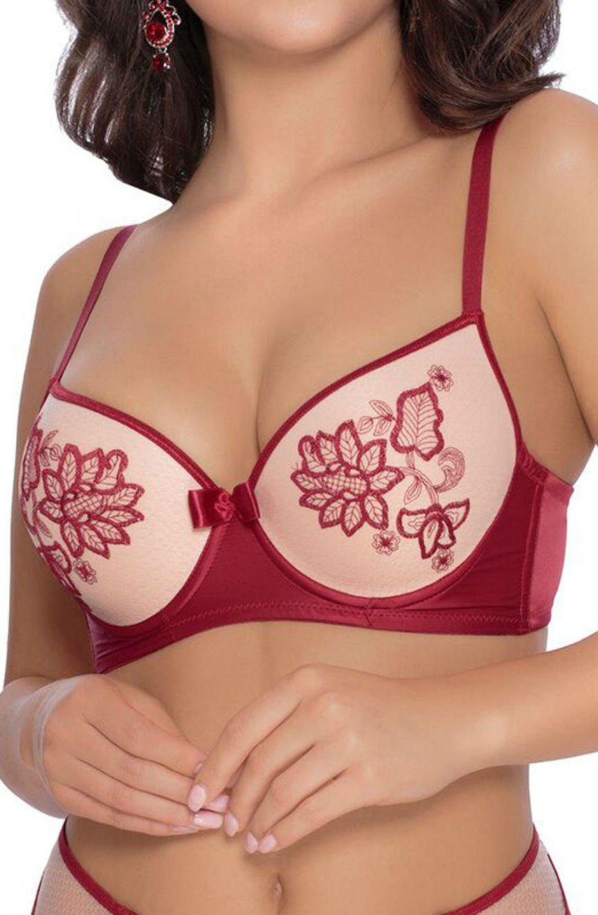 A woman wearing the Roza Mehendi Push Up Bra Claret with its stunning red and beige tones, featuring delicate floral embroidery on the cups. The intricate flower and leaf designs echo the elegance of bridal mehendi. She is shown from the shoulders down, with no facial features visible, lightly holding her hands in front of her.