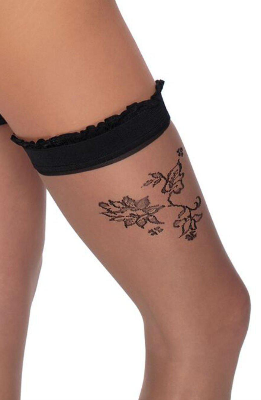 Close-up of a person's upper thigh wearing Roza Mehendi Stockings Black, adorned with sheer floral patterns that resemble intricate Mehendi designs and paired with a black lace garter. These elegant stockings, featuring detailed flowers and butterflies, mimic the beauty of Henna stockings. The background is plain white.