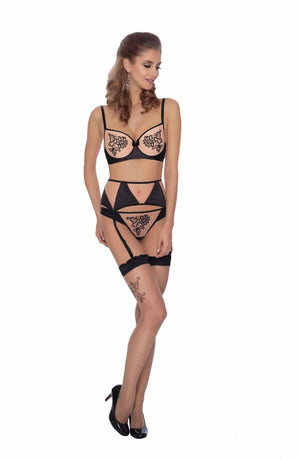 A woman is modeling the Roza Mehendi Thong Black lingerie set, which includes a bra, garter belt, and thong paired with high heels. The intricate floral designs on the lingerie are reminiscent of henna art. She stands against a plain white background, looking to her side.