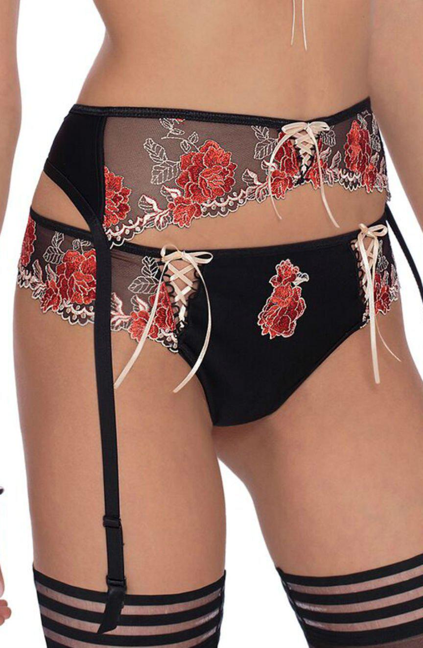 A person is wearing black lingerie with lace detailing featuring red floral embroidery. The outfit includes a garter belt with ribbons and sheer fabric accents, paired with matching Roza Natali Black Briefs from the brand Roza. The image showcases the back view of the lingerie set.