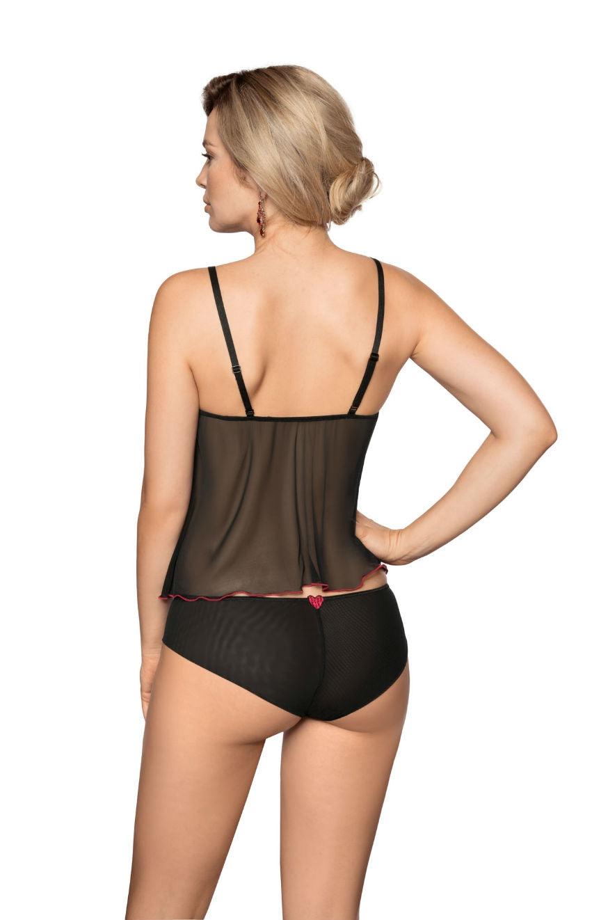 A woman is seen from the back, wearing black lingerie from Roza that includes a sheer sleeveless top and Roza Rubii Black Briefs adorned with red heart embroidery. She has blonde hair styled in an updo and stands with one hand on her hip against a plain white background.