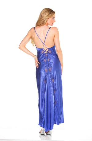 A woman with long blond hair is facing away from the camera, wearing the Shirley Of Hollywood 20300 Blue Long Gown by Shirley of Hollywood. The floor-length, backless blue satin gown features elegant crisscross straps and delicate lace trim. She stands with one hand on her hip, showcasing her bracelet and is wearing high heels.