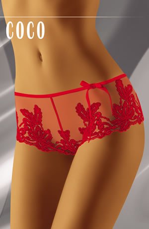 A close-up of a person modeling Wolbar Coco Red Shorts by Wolbar, featuring exquisite floral embroidery and an elegant bow, highlighting the lower torso and upper thigh area. The word "COCO" appears in bold white uppercase letters at the top against a sleek grey gradient background.